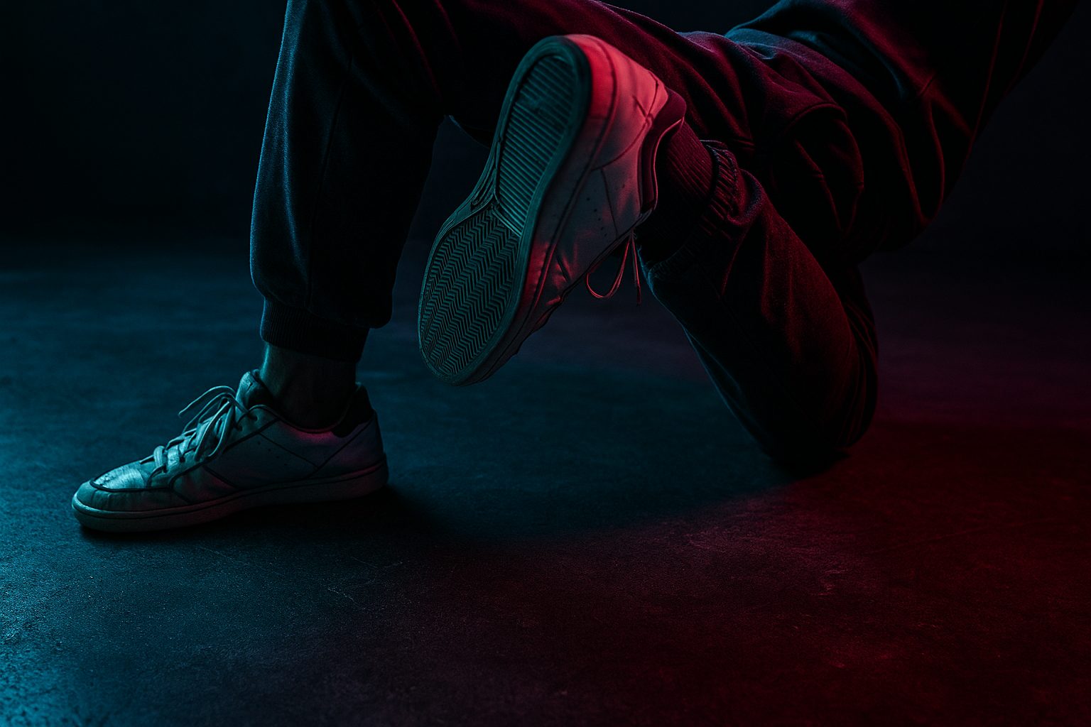 Bailarines practicando distintos estilos urbanos en el estudio con iluminación nocturna